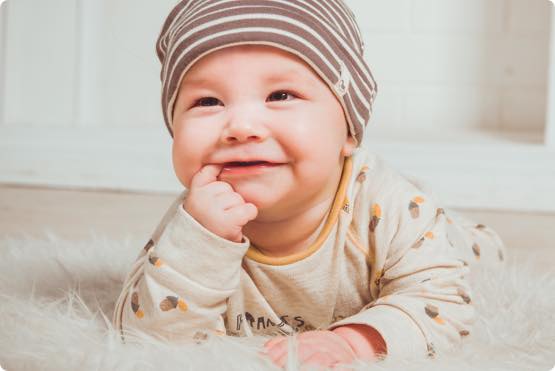 A baby with a finger in his mouth.